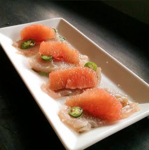 tuna served over slices of fish and sliced jalapeños