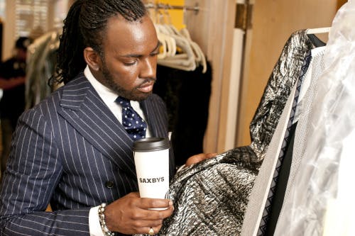 a person holding a cup of coffe ewhile checking the quality of the fabric