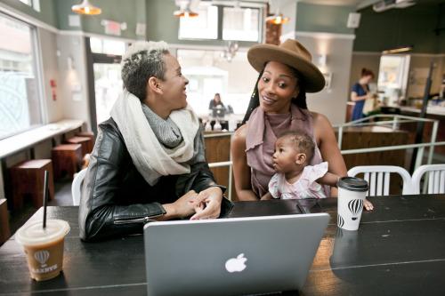 egy asztalnál ülő emberek egy csoportja, akik egy laptopot használnak