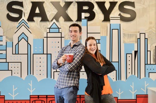 a man and a woman standing and smiling for the camera