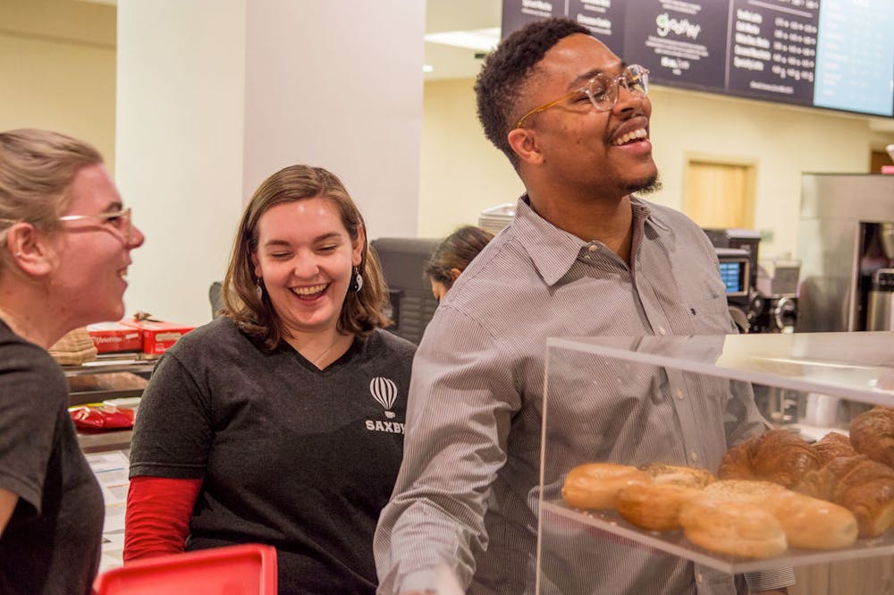 a man and a woman standing in front of a doughnut