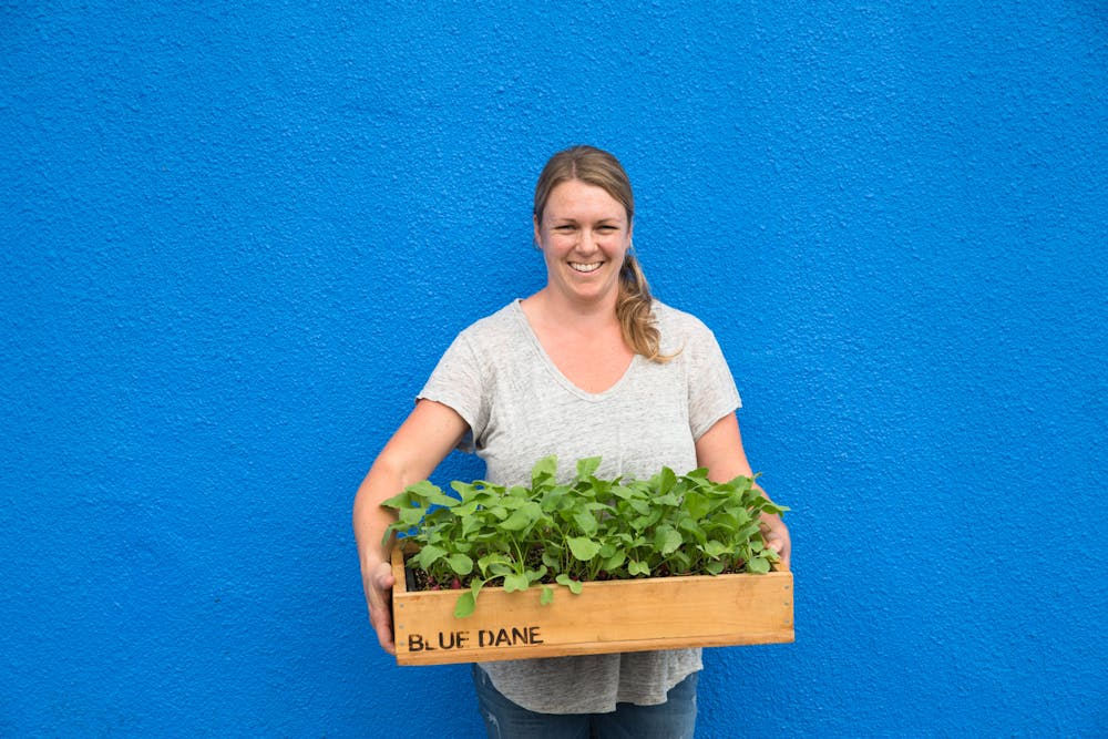 women holding blue dane garden's plants