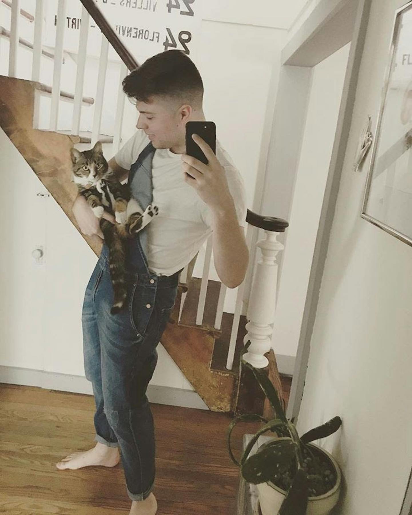 a man holding a fish in front of a mirror posing for the camera