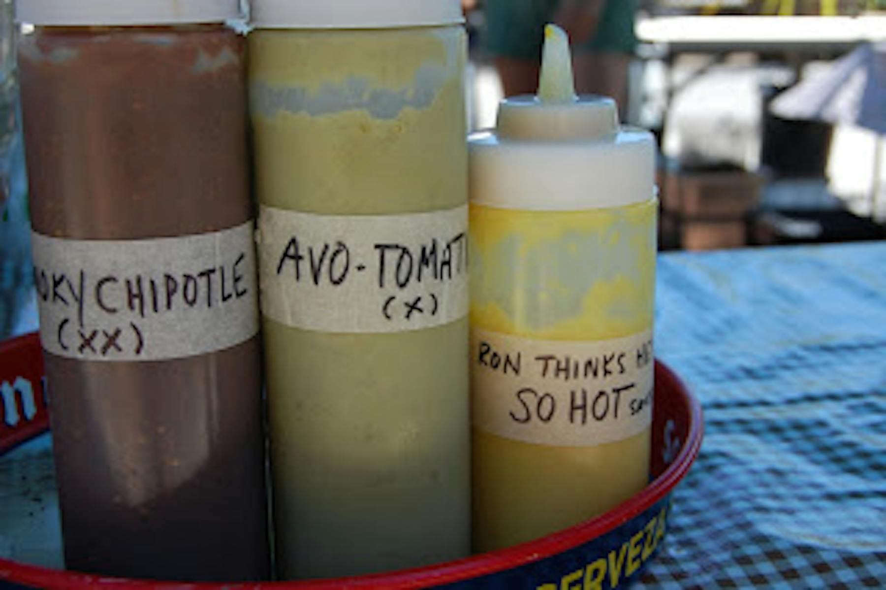 three bottles of chipotle, avo tomato, and a yellow sauce