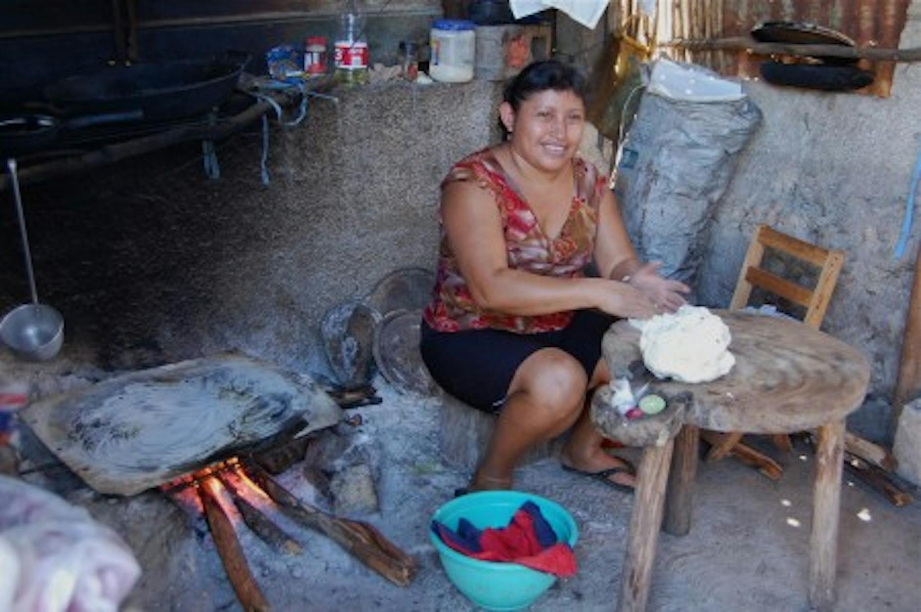a woman making tortillas outside