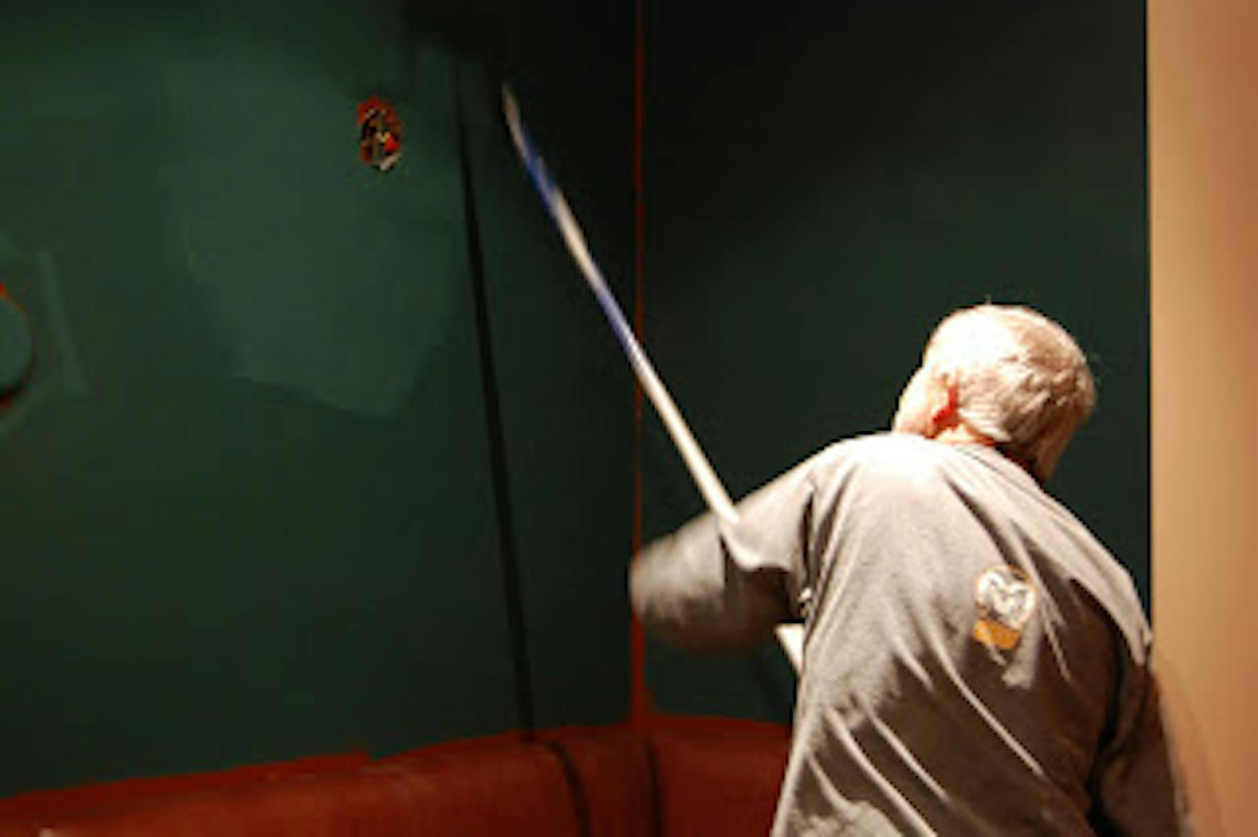a man painting the wall green