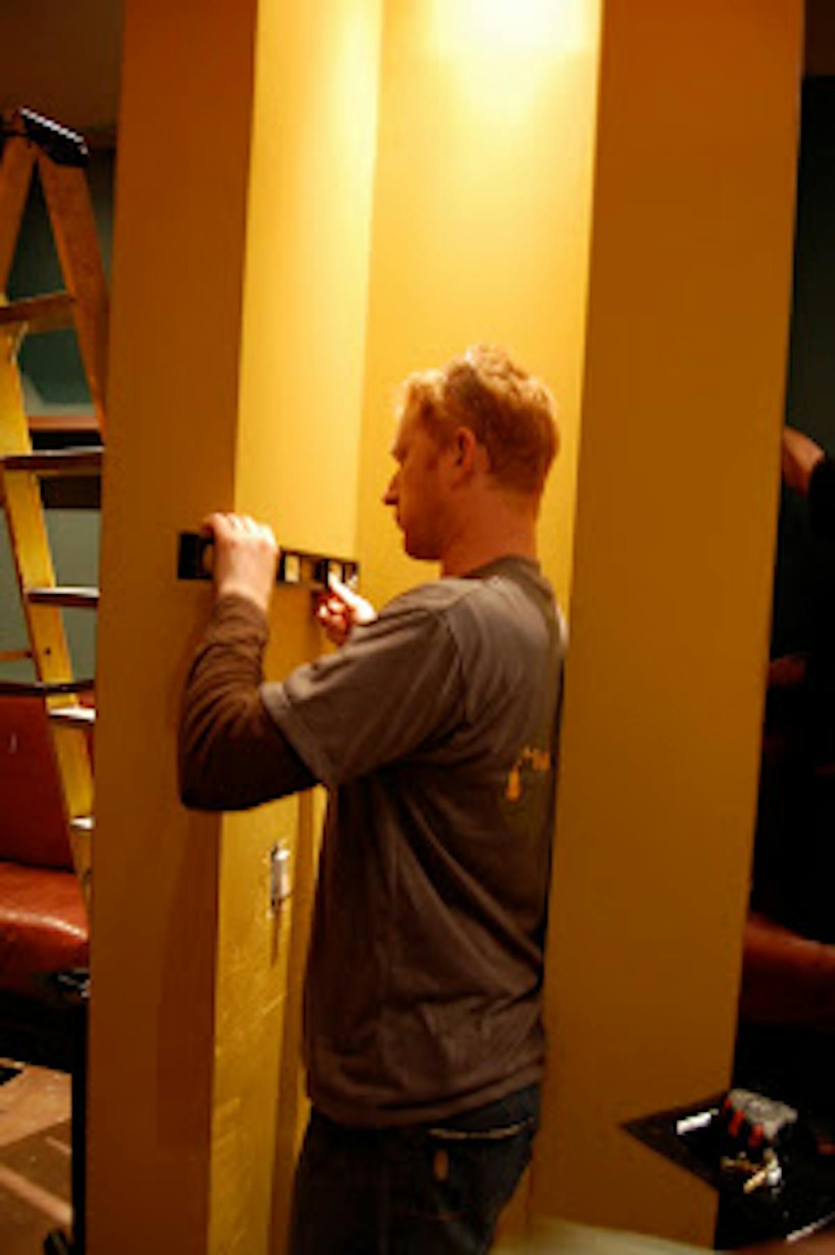 a man painting the wall yellow