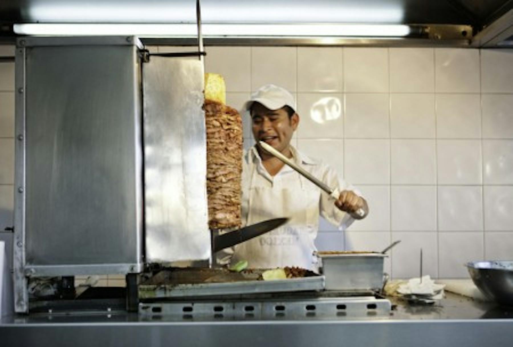 a man making al pastor meat