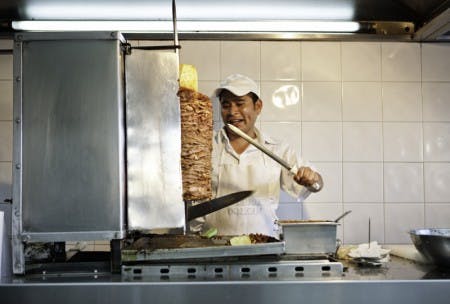 _F7U4500 a man making al pastor meat