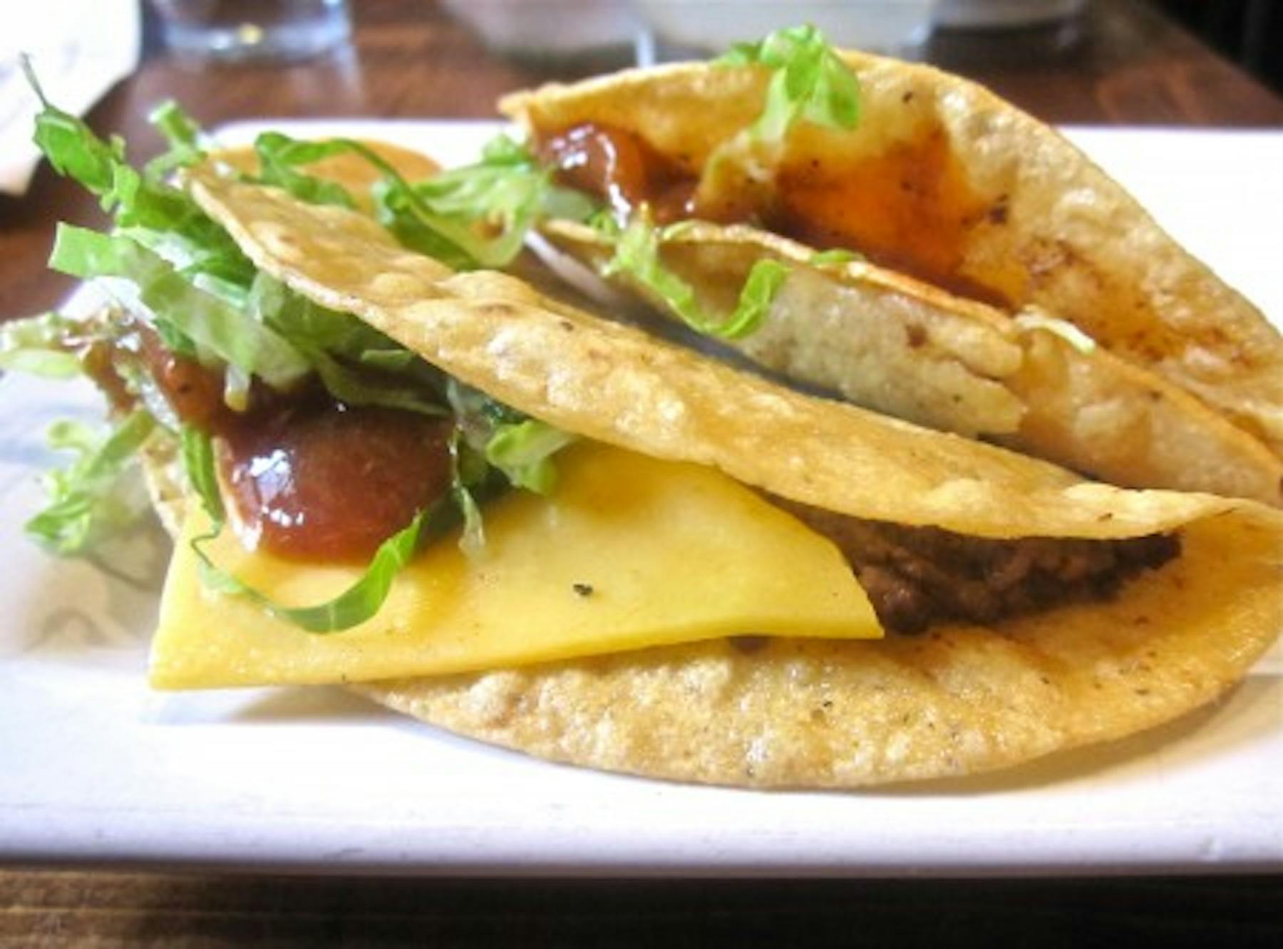 fried tortillas with ground meat and cheese with diced lettuce