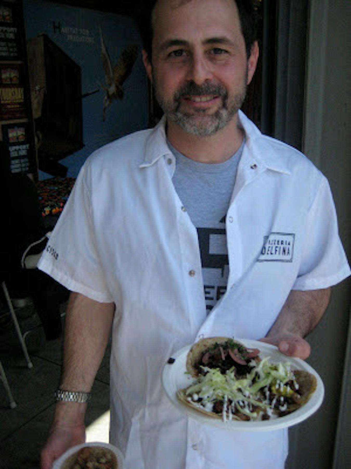 a man holding a plate of tacos