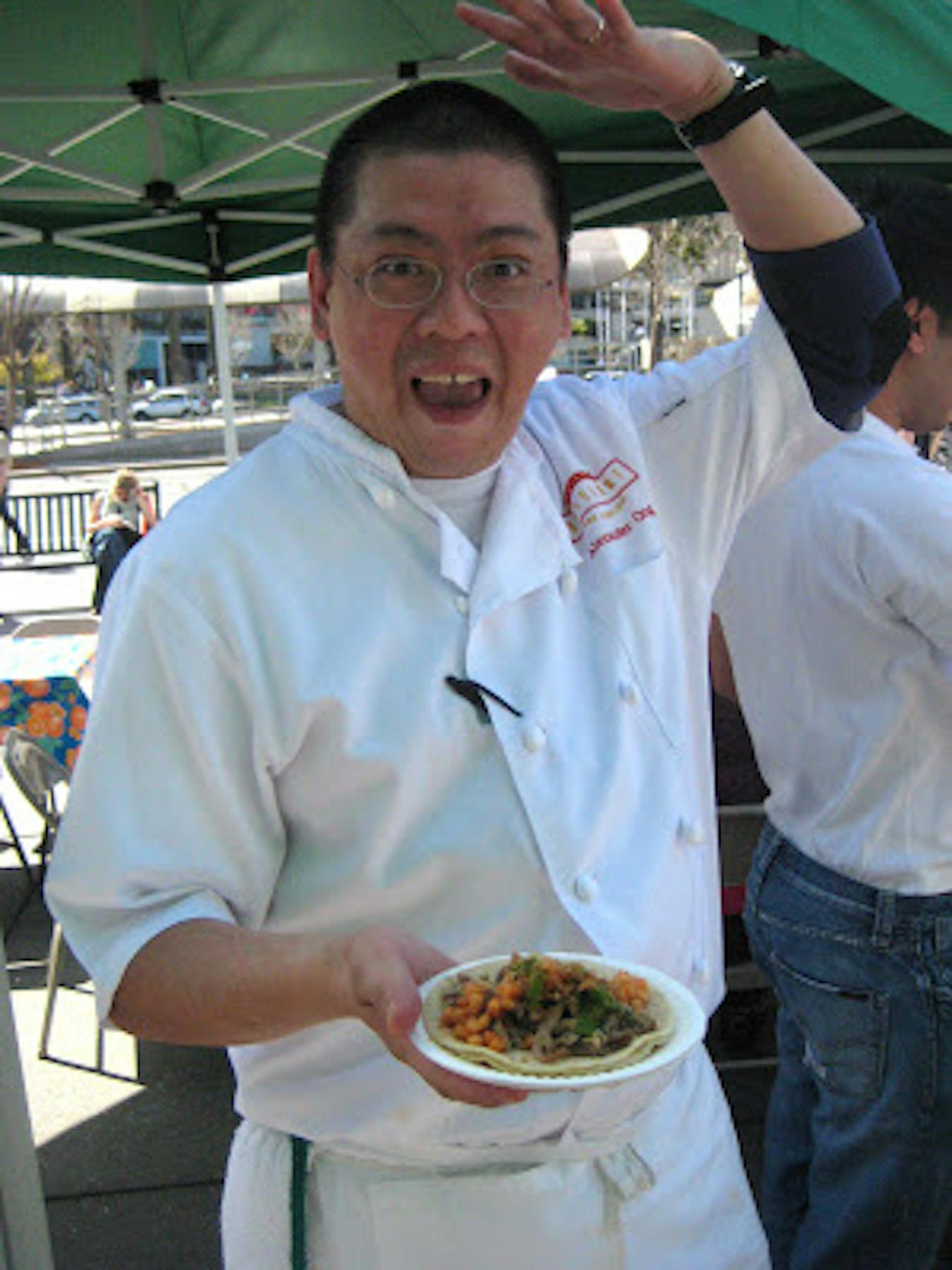 Alex Ong posing with a plate of taco