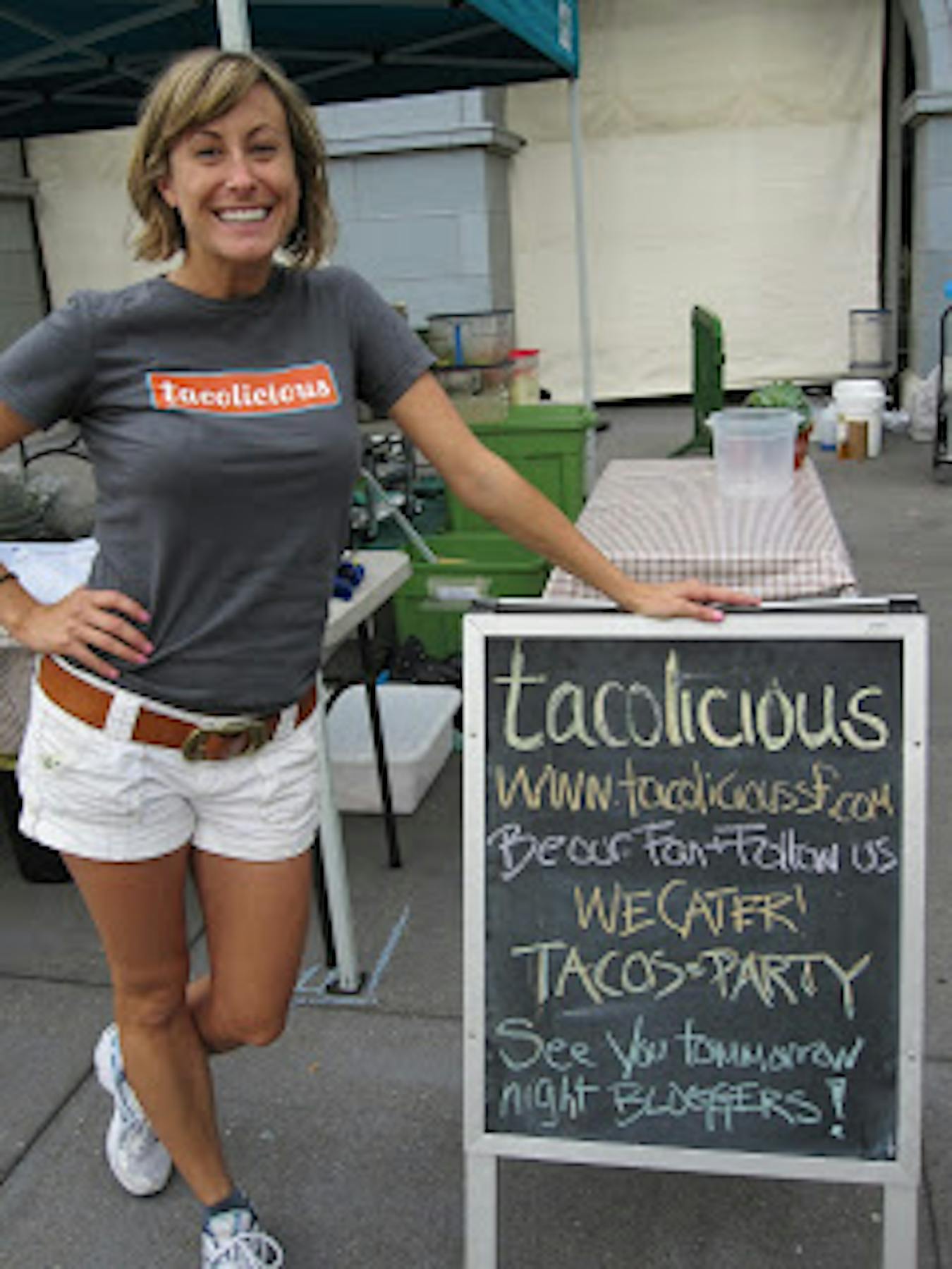 kelly posing beside a tacolicious sign