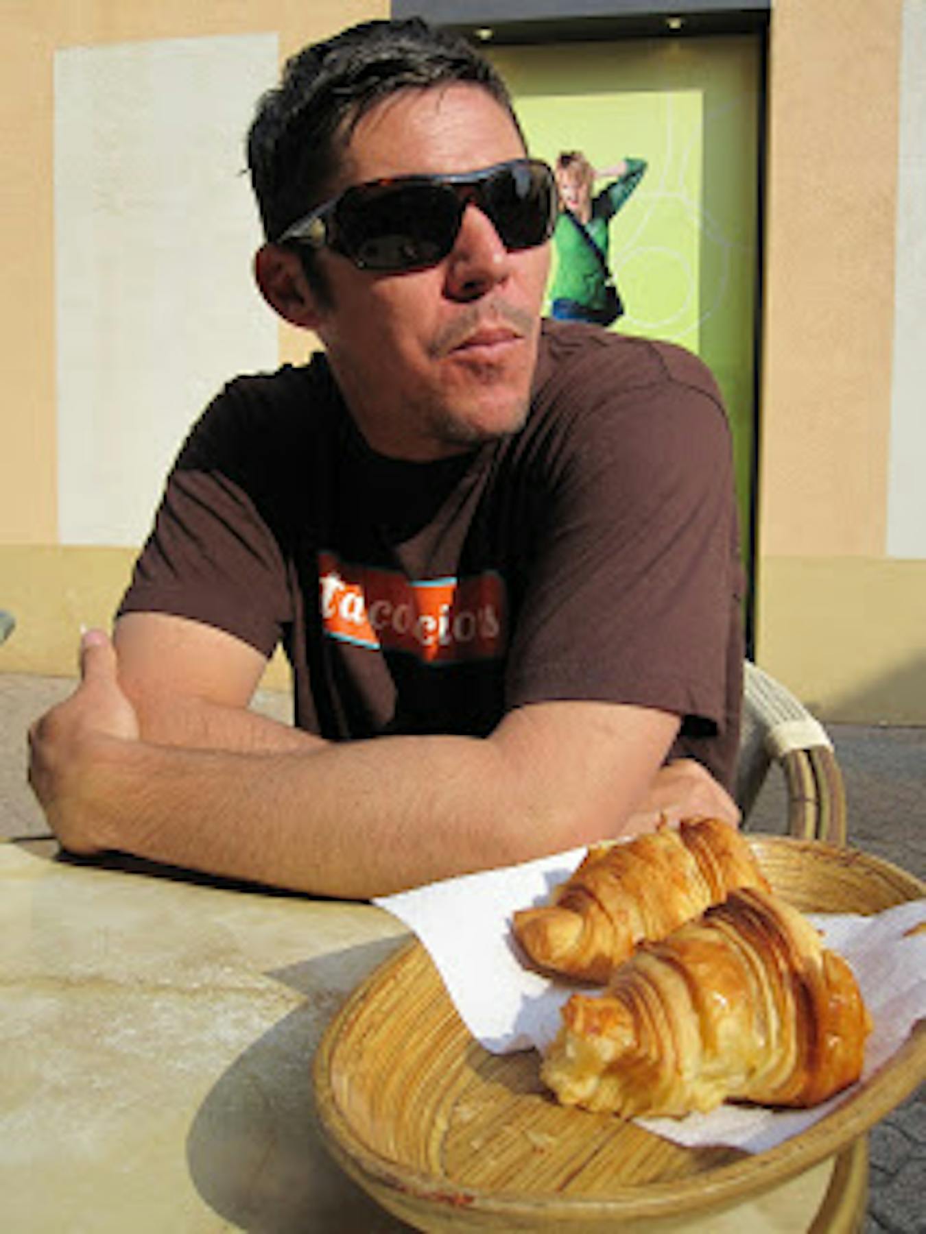 a man wearing glasses and two breads beside him