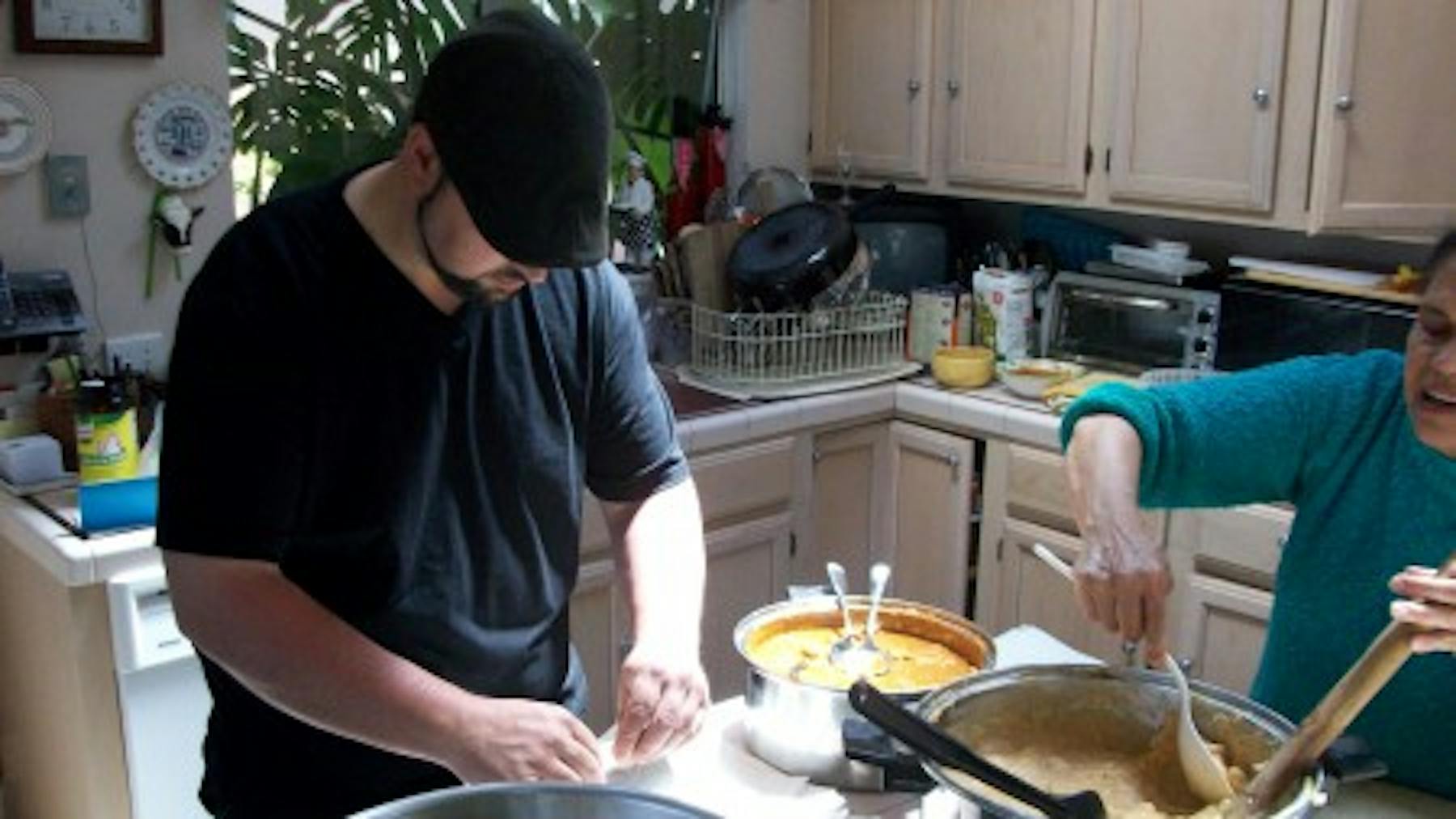 Ms Reyes and a man preparing food at the kitchen