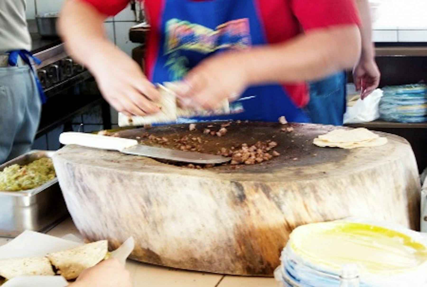 hands dicing meat and preparing tacos