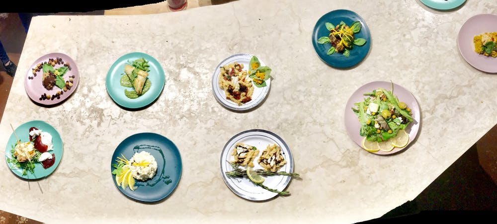 a white table with 9 plates spaced out with beautiful food on them