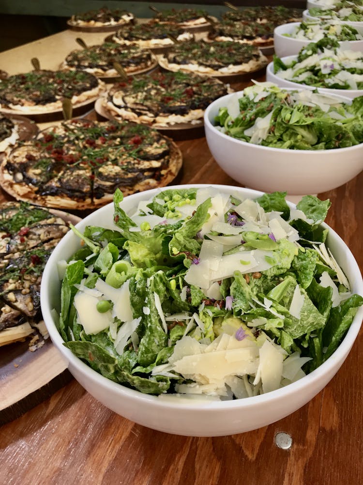 a buffet of salads and eggplant tartes