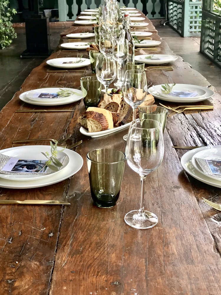 Long wooden table set with glassware and white plates