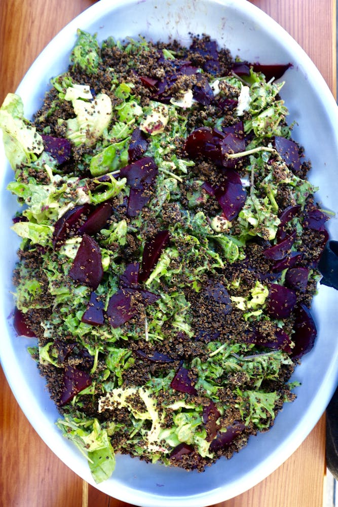 an oval bowl filled with lettuce and purple beets