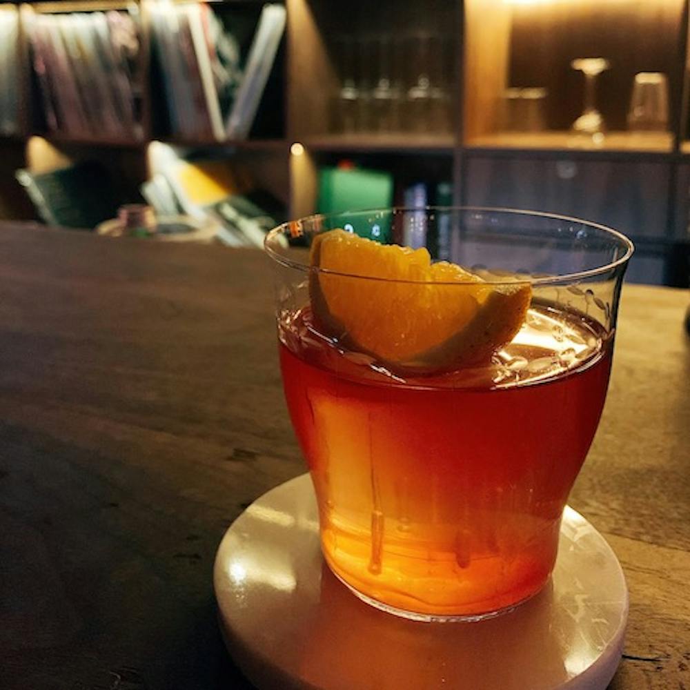 a glass of alcoholic beverage with half a lemon floating on top