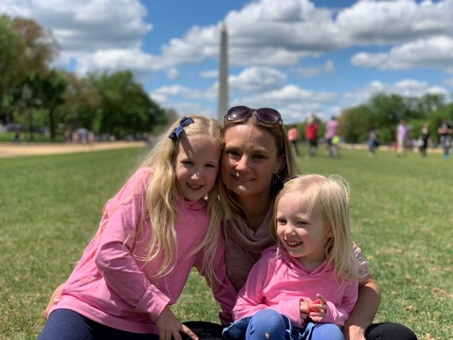 a little girl sitting in a field