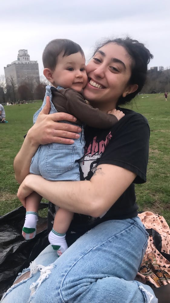 a little girl that is sitting in the grass